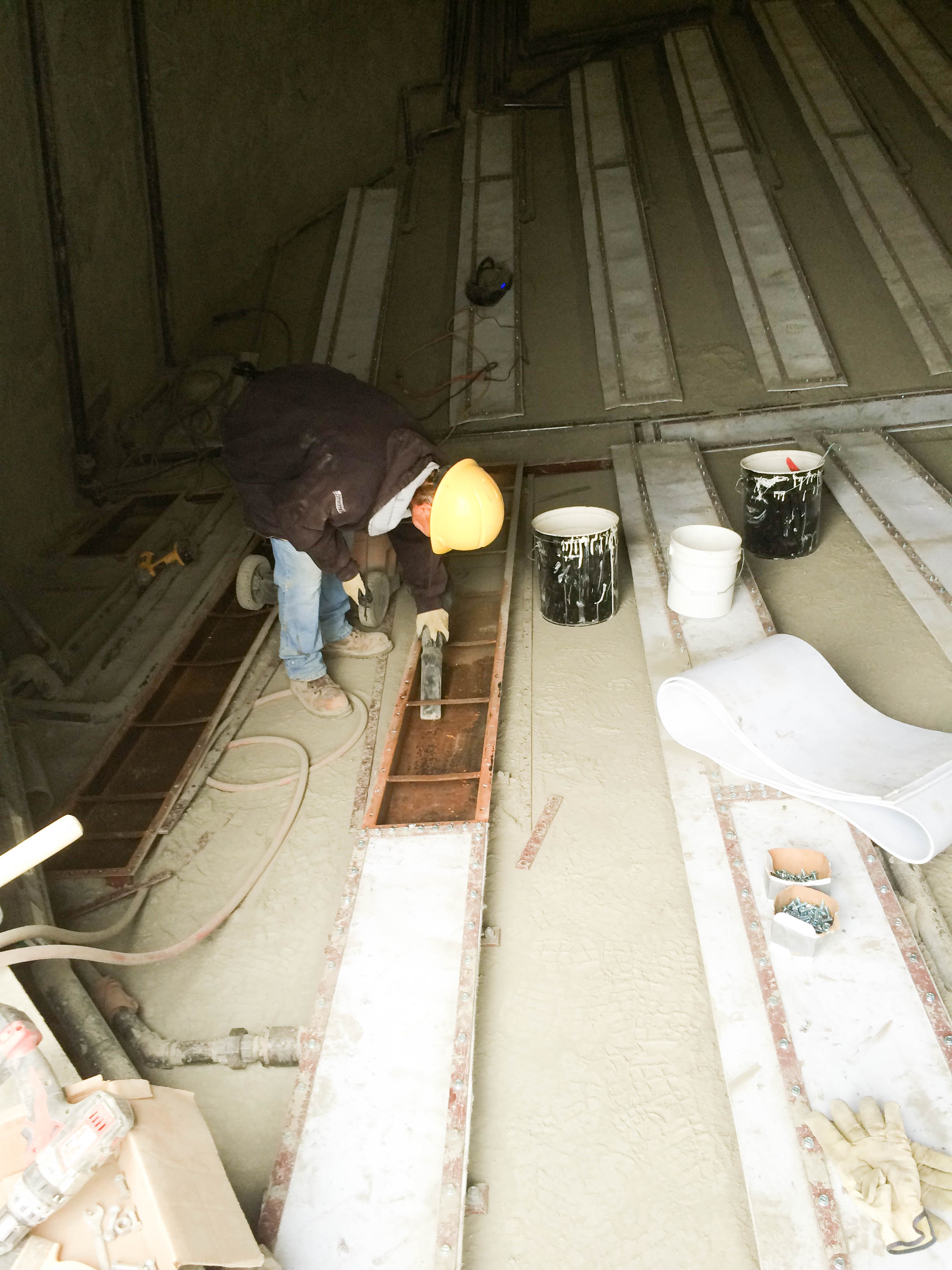 Men adding silo coating to silo